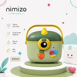 A nimizo Mini Zone 500ml mini food container in sage green and yellow, decorated with cute cartoon carrot and cherry magnets, displayed on a white and green pedestal with product feature icons on a light background.
