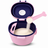 A pink and navy blue baby feeding container with its lid open, showing white powder being poured into a bone-shaped pink scoop.