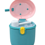 A teal and pink plastic toy ice cream maker container with a yellow latch, shown open with a white scoop inside, on a white background.