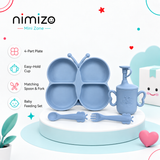 Nimizo Mini Zone baby feeding set in light blue, featuring a 4-part butterfly-shaped plate, matching cup, spoon, and fork, displayed on a white pedestal with product feature icons on a clean white background.