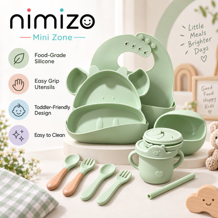 Nimizo Mini Zone baby feeding set in light green silicone, including a plate, bib, bowls, utensils, and cup, displayed on a white pedestal with product feature callouts on the left.